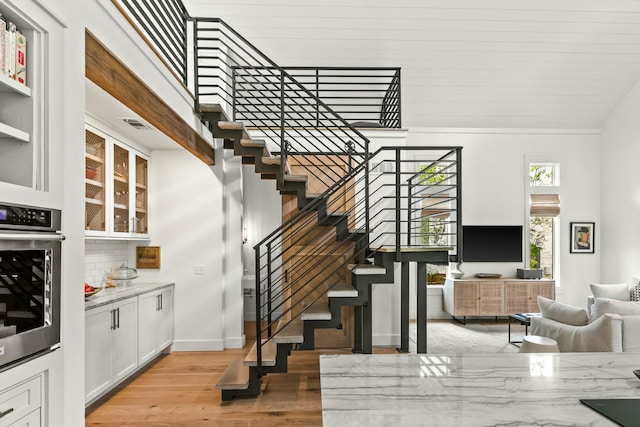 staircase featuring hardwood / wood-style floors and a high ceiling