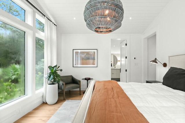 bedroom featuring connected bathroom, wooden ceiling, light wood-type flooring, and a notable chandelier