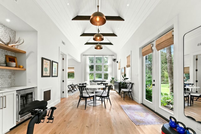 dining space featuring high vaulted ceiling, light hardwood / wood-style floors, wood ceiling, and wine cooler