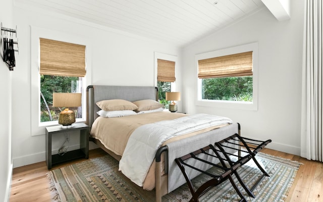 bedroom with light hardwood / wood-style flooring, wood ceiling, and vaulted ceiling