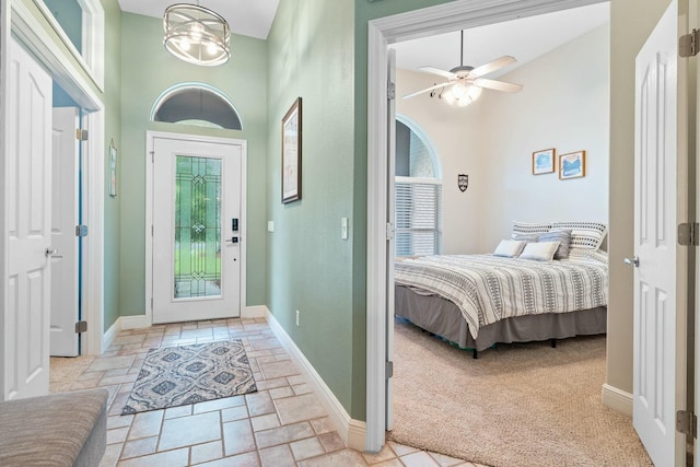 carpeted bedroom featuring ceiling fan with notable chandelier, a high ceiling, and access to outside