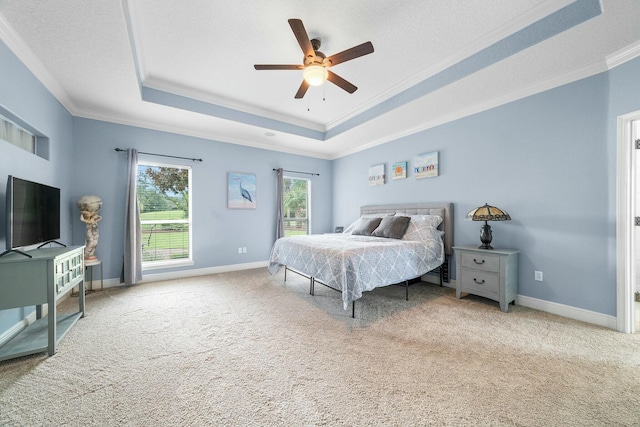 bedroom featuring carpet, ceiling fan, a raised ceiling, and ornamental molding