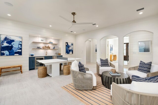 living room featuring ceiling fan, indoor wet bar, and wine cooler