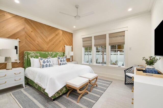 bedroom with ceiling fan, wooden walls, and crown molding