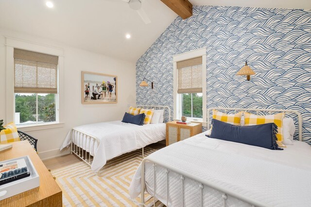 bedroom with lofted ceiling with beams, light hardwood / wood-style flooring, and ceiling fan