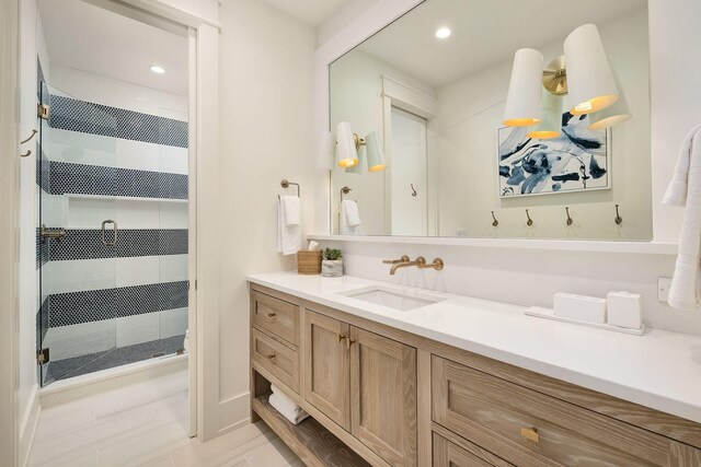 bathroom with a tile shower and vanity