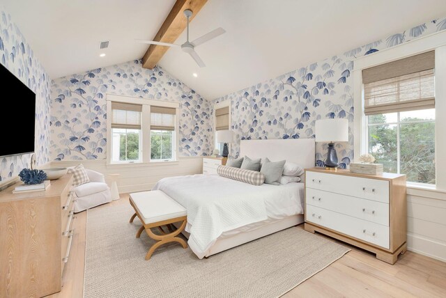 bedroom with multiple windows, ceiling fan, light hardwood / wood-style flooring, and lofted ceiling with beams