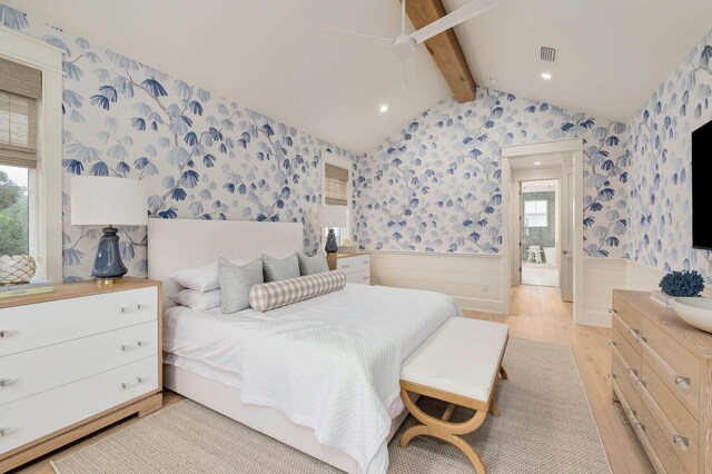 bedroom with connected bathroom, ceiling fan, lofted ceiling with beams, and light wood-type flooring