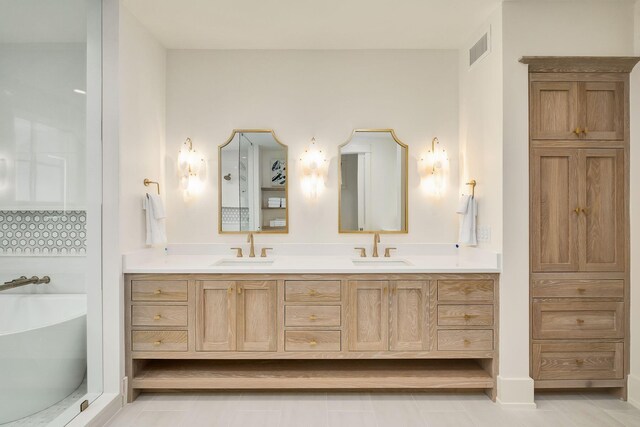 bathroom featuring a bathtub, vanity, and tile patterned flooring