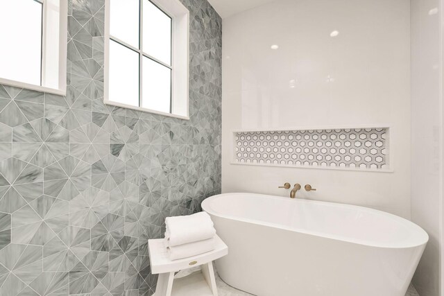 bathroom with a bathtub and tile walls