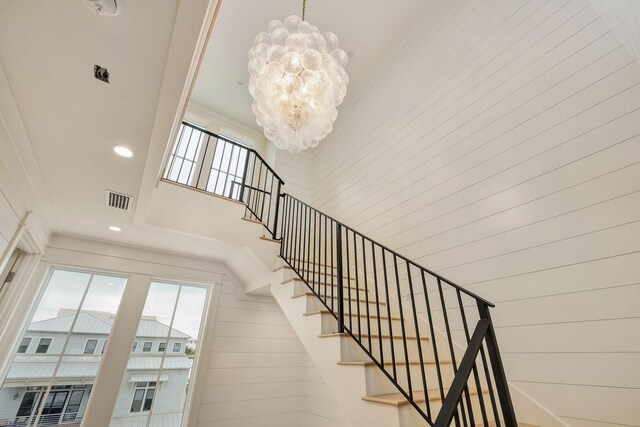 stairs with a towering ceiling and a chandelier