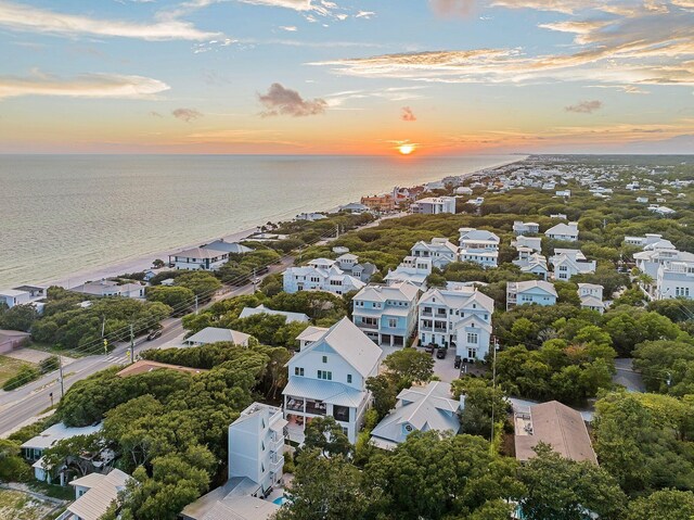 aerial view at dusk featuring a water view