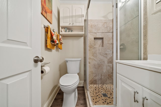 bathroom with ornamental molding, vanity, hardwood / wood-style flooring, toilet, and a shower with shower door