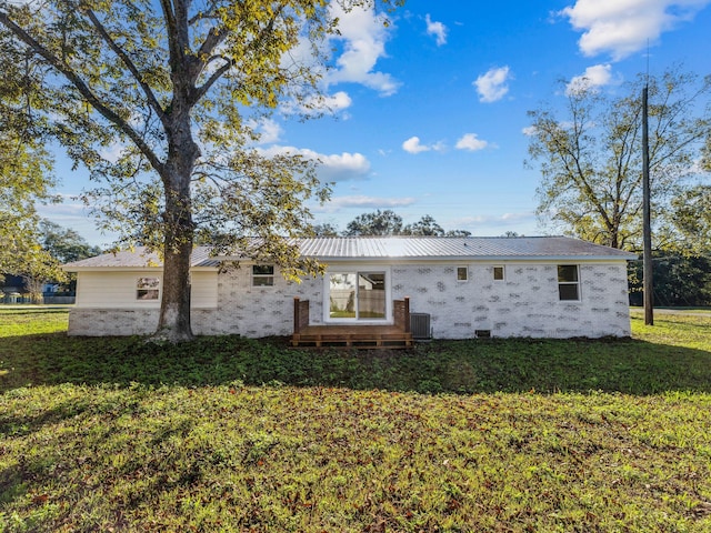 rear view of house with a yard and central AC