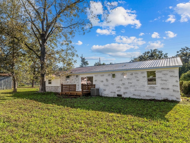 back of house featuring a yard, central AC unit, and a wooden deck