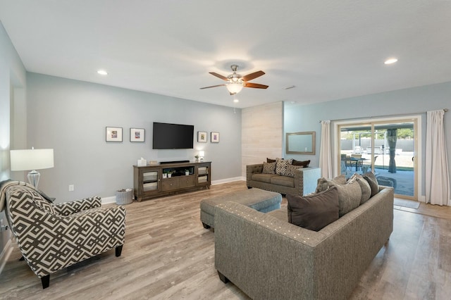 living room featuring ceiling fan and light hardwood / wood-style flooring