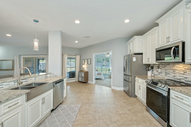 kitchen with tasteful backsplash, stainless steel appliances, sink, decorative light fixtures, and white cabinetry