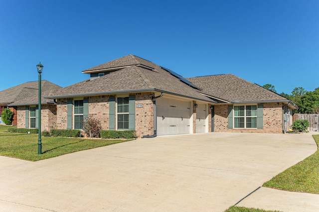 ranch-style home with a garage and a front lawn