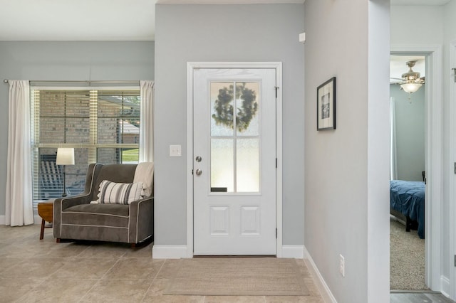 foyer featuring light tile patterned floors, ceiling fan, and a healthy amount of sunlight