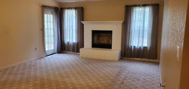 unfurnished living room with light carpet and a brick fireplace