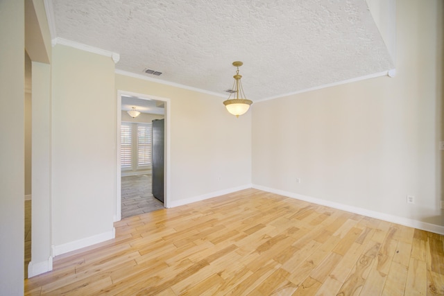 empty room with wood-type flooring, a textured ceiling, and ornamental molding