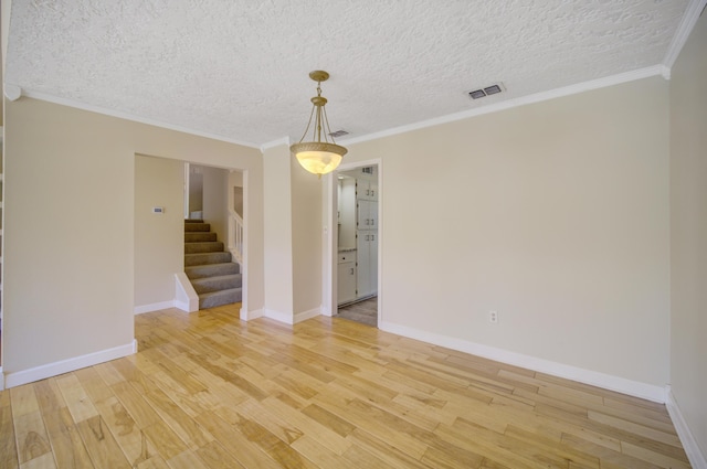 unfurnished room with ornamental molding, a textured ceiling, and hardwood / wood-style flooring