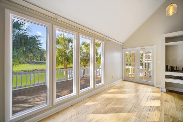 entryway with light hardwood / wood-style flooring, high vaulted ceiling, and french doors