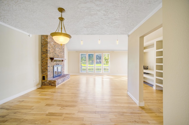 unfurnished living room featuring light wood-type flooring, a textured ceiling, and a brick fireplace