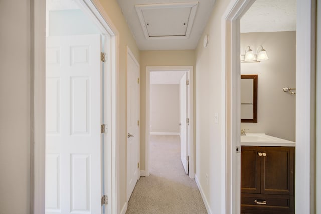 hallway with light colored carpet and sink