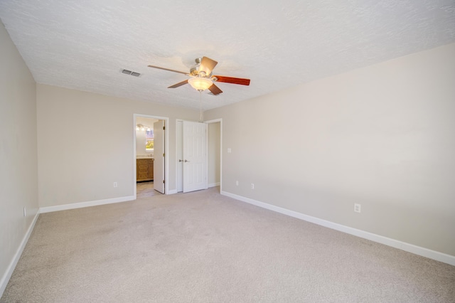 unfurnished room with light carpet, ceiling fan, and a textured ceiling