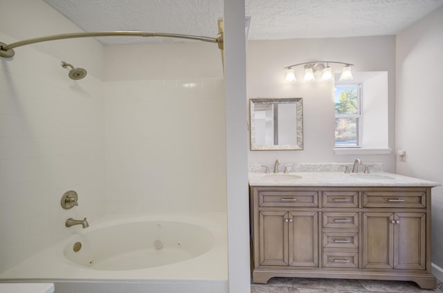 bathroom with vanity, a textured ceiling, and tiled shower / bath