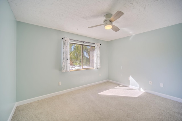 unfurnished room featuring a textured ceiling, light colored carpet, and ceiling fan