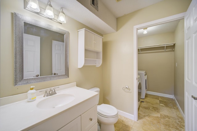 bathroom featuring vanity, washer / clothes dryer, and toilet