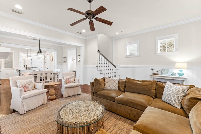 living room featuring light hardwood / wood-style flooring, ceiling fan, and ornamental molding