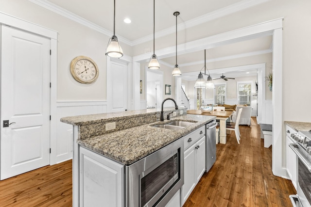 kitchen with dark hardwood / wood-style flooring, stainless steel appliances, ceiling fan, sink, and decorative light fixtures