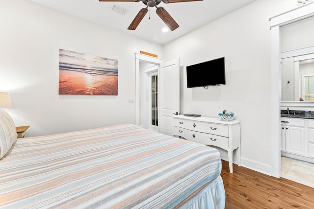 bedroom featuring connected bathroom, ceiling fan, light hardwood / wood-style flooring, and sink