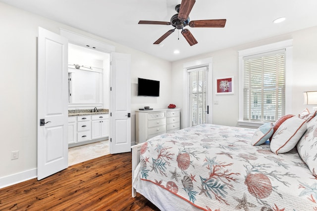 bedroom featuring ceiling fan, dark hardwood / wood-style floors, sink, and ensuite bathroom