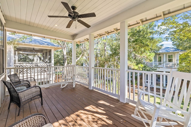 wooden terrace with a sunroom and ceiling fan