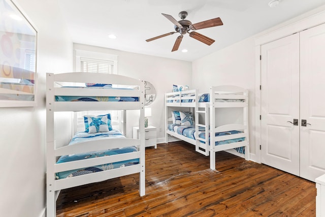 bedroom with ceiling fan, dark wood-type flooring, and a closet