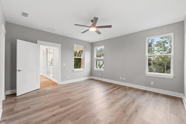 unfurnished room with ceiling fan, light hardwood / wood-style floors, and a wealth of natural light