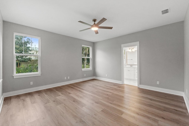 spare room featuring ceiling fan, a healthy amount of sunlight, and light wood-type flooring