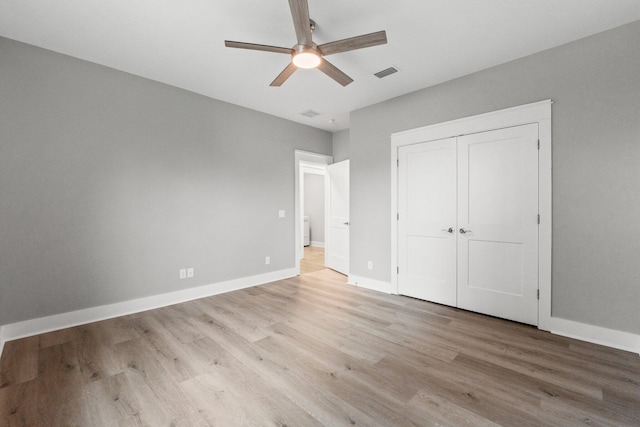 unfurnished bedroom featuring ceiling fan, light wood-type flooring, and a closet