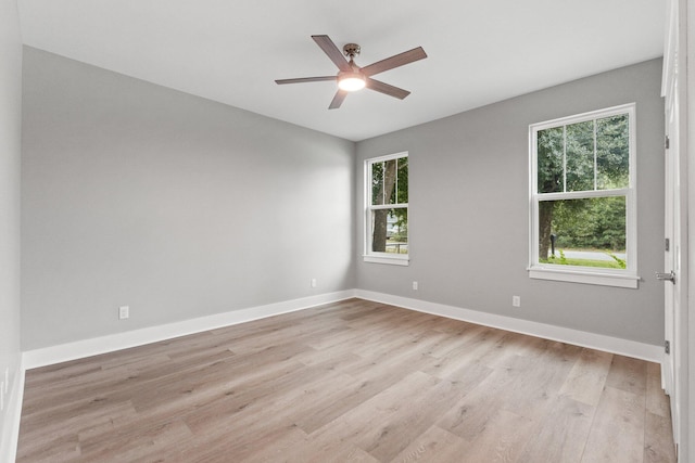 empty room with light wood-type flooring, ceiling fan, and a healthy amount of sunlight