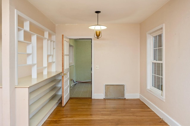 unfurnished dining area featuring hardwood / wood-style flooring and built in features