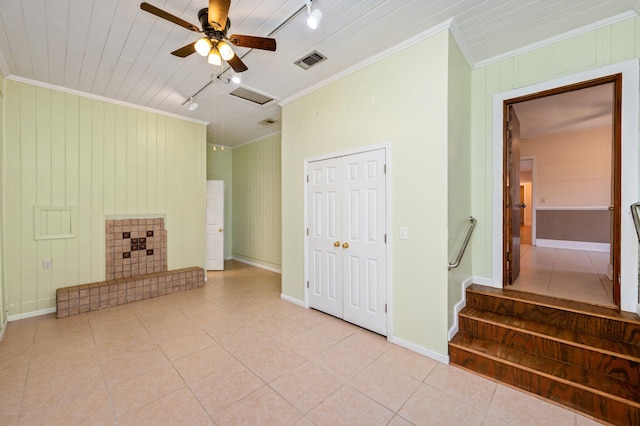 unfurnished living room with light tile patterned floors, rail lighting, ceiling fan, and crown molding