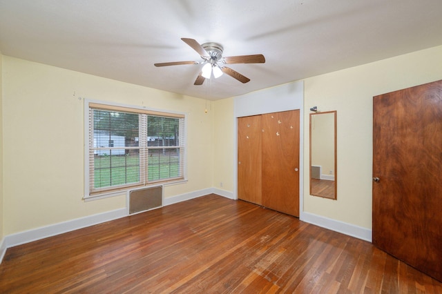 unfurnished bedroom with ceiling fan, a closet, and dark hardwood / wood-style floors