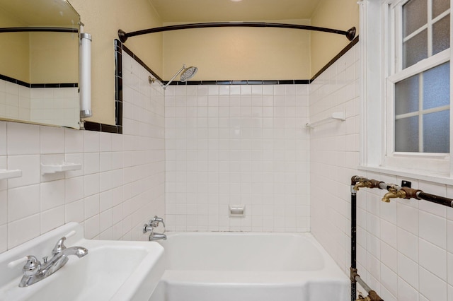 bathroom with sink, tile walls, and tiled shower / bath combo