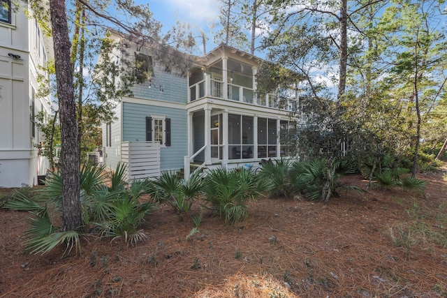 back of house with a sunroom and a balcony