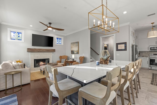 dining room featuring crown molding, light hardwood / wood-style flooring, and ceiling fan with notable chandelier