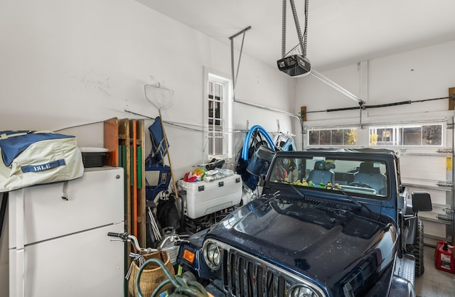 garage featuring white refrigerator and a garage door opener